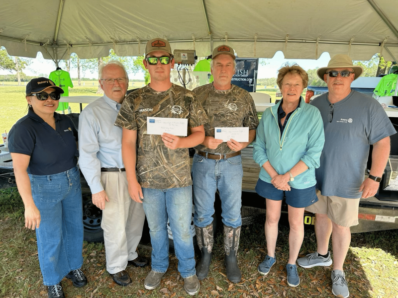 group of people posing for a picture outside under a tent