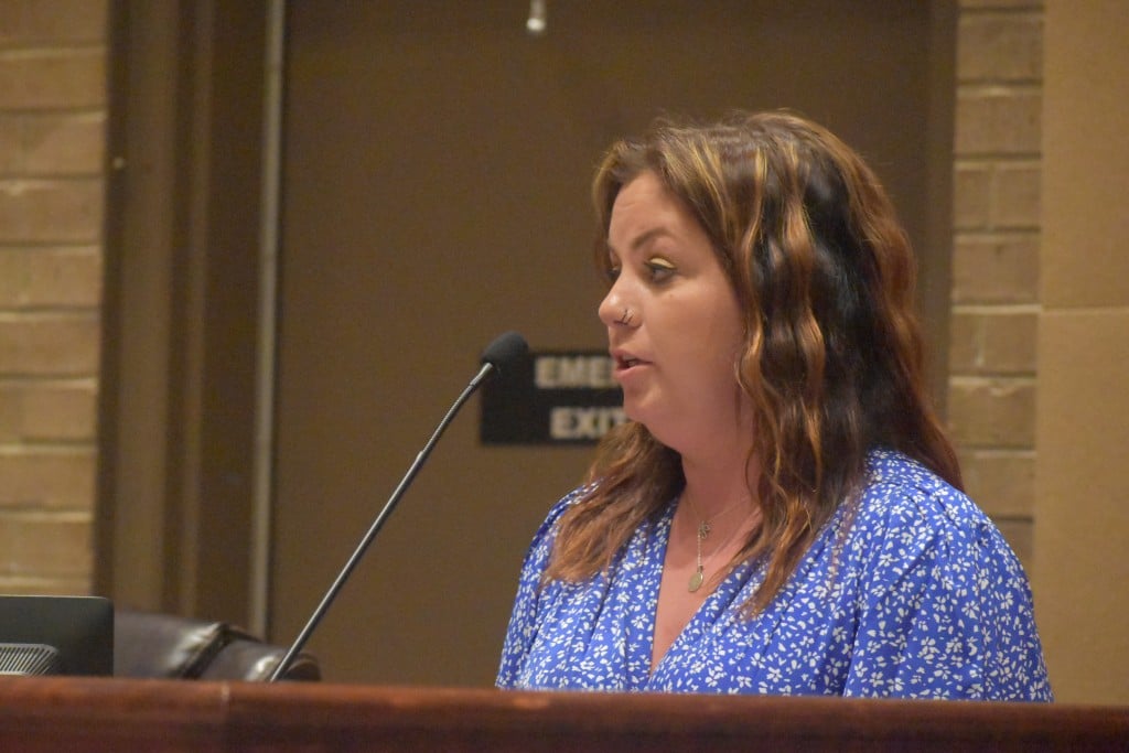 Kristina Carlisle, a young woman, speaking at a podium
