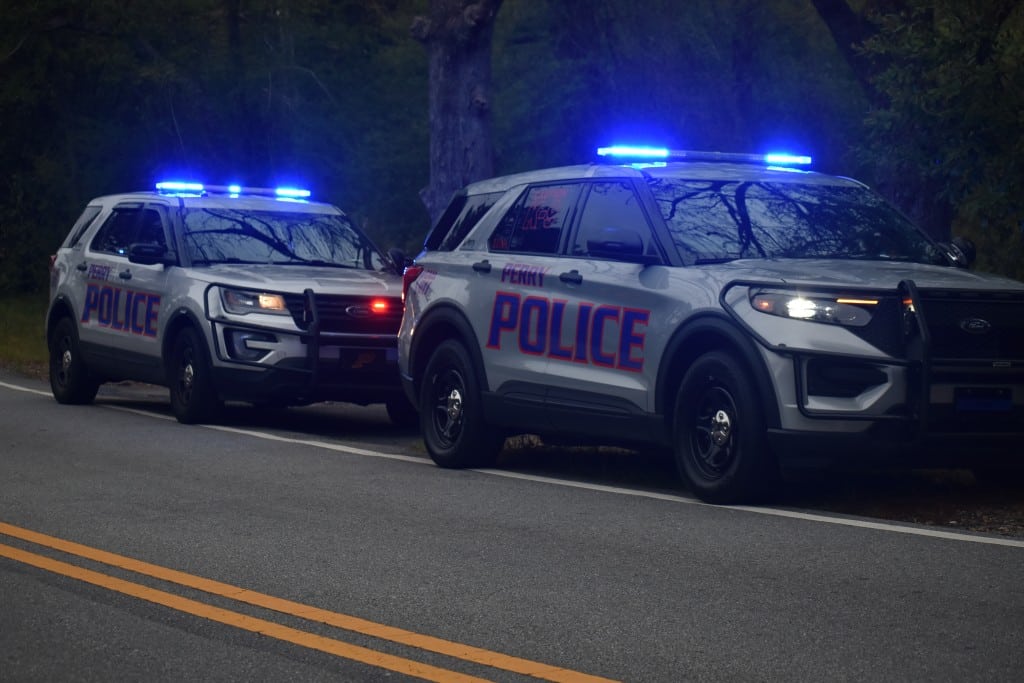 Two Perry Police Department Squad Cars with sirens on