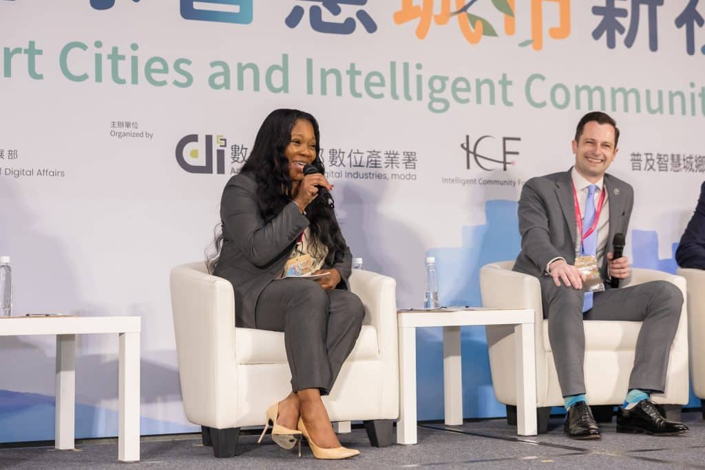 Mayor LaRhonda Patrick, a woman representing the city of Warner Robins, sits in a chair on stage speaking into a microphone