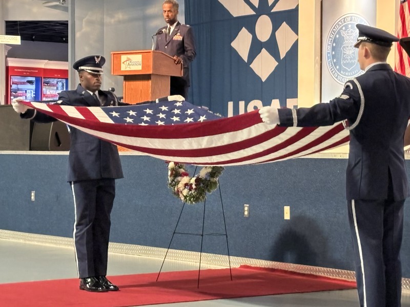 two airmen unfolding the American Flag