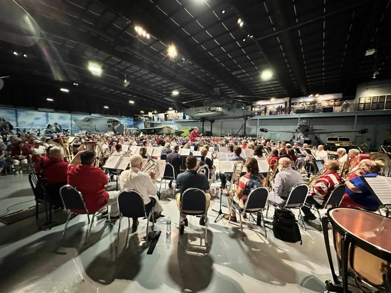 a lot of band members gathered in a circular formation playing their instruments