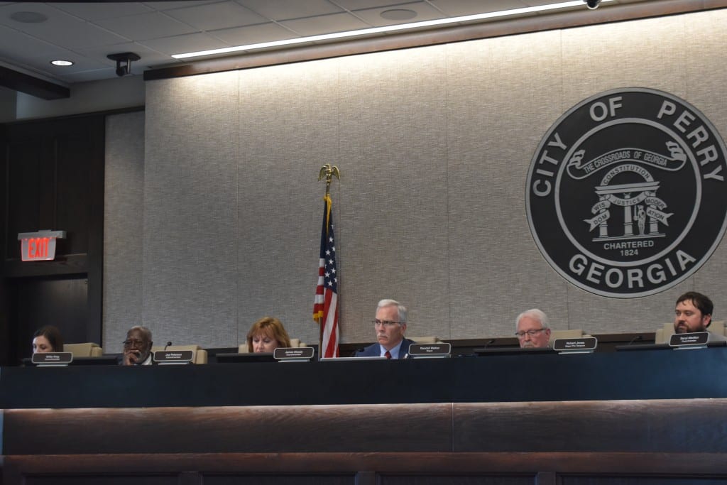 People sitting behind a council desk.