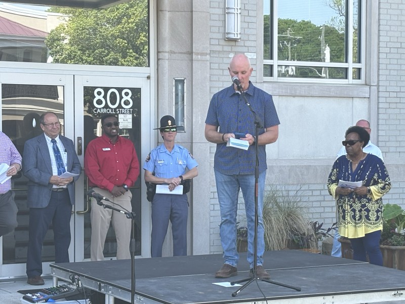 Man speaking on a stage with four people in the background