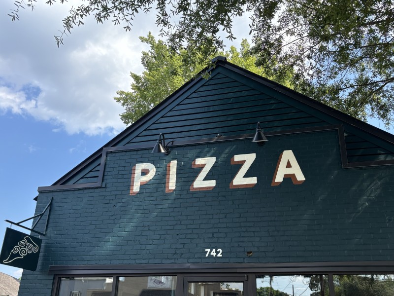 green brick and mortar building with pizza in capital letters across it