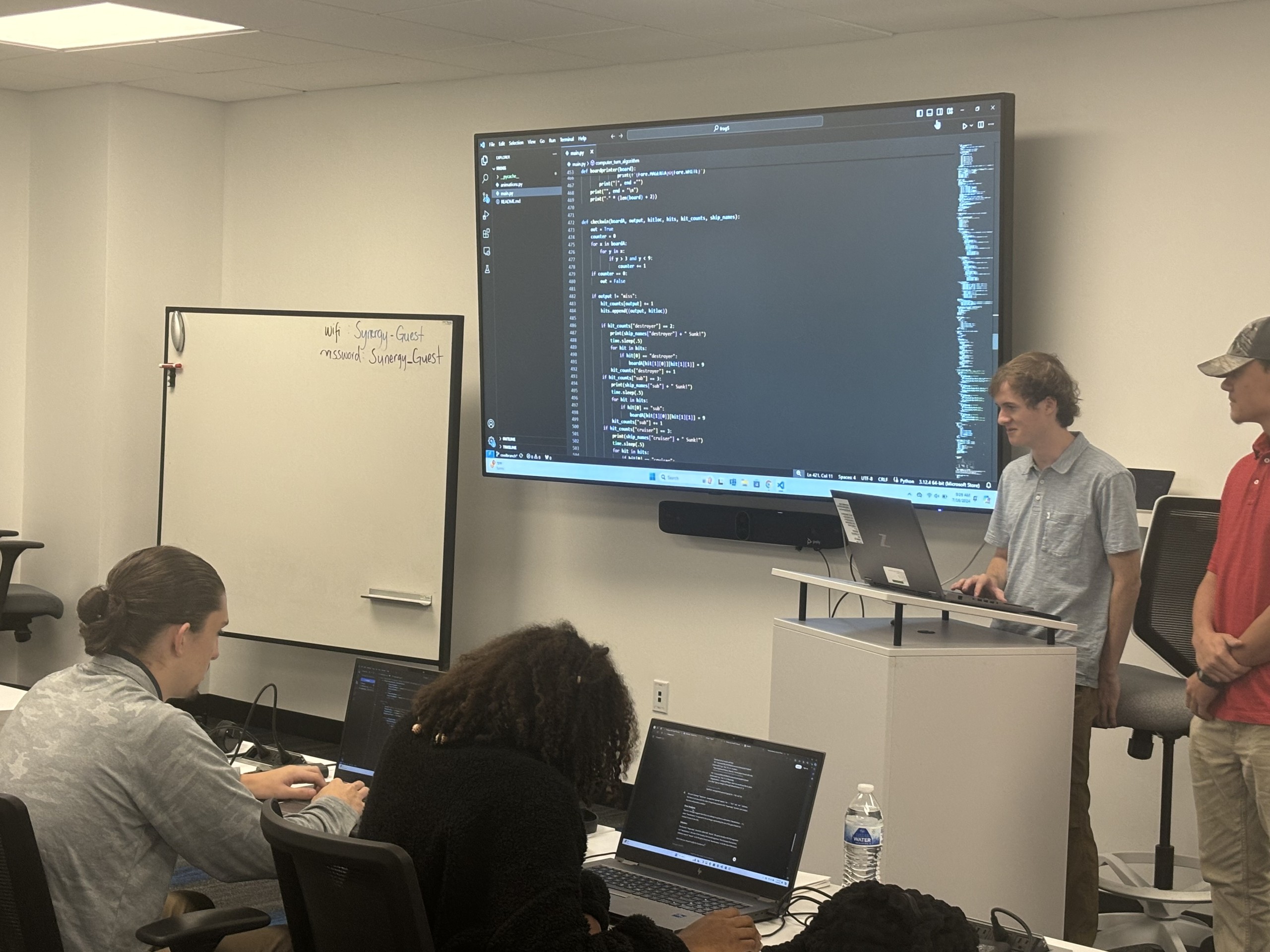 young man showing a class what code he was working on