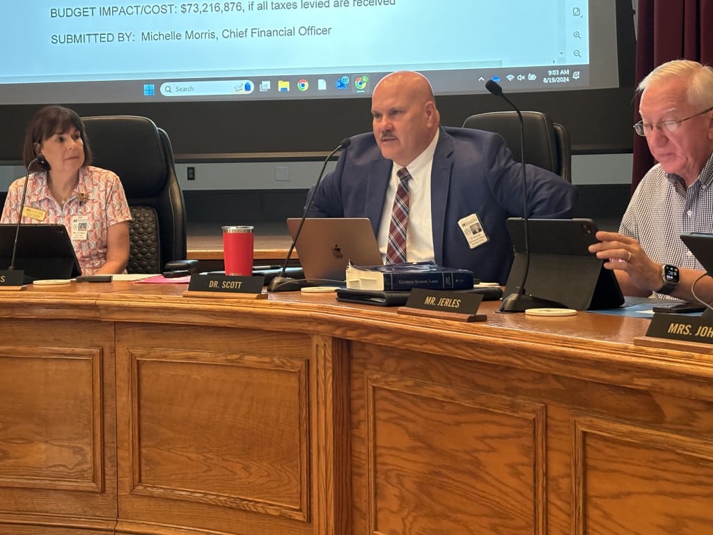 three individuals, one women two men. Men in the middle wearing suit