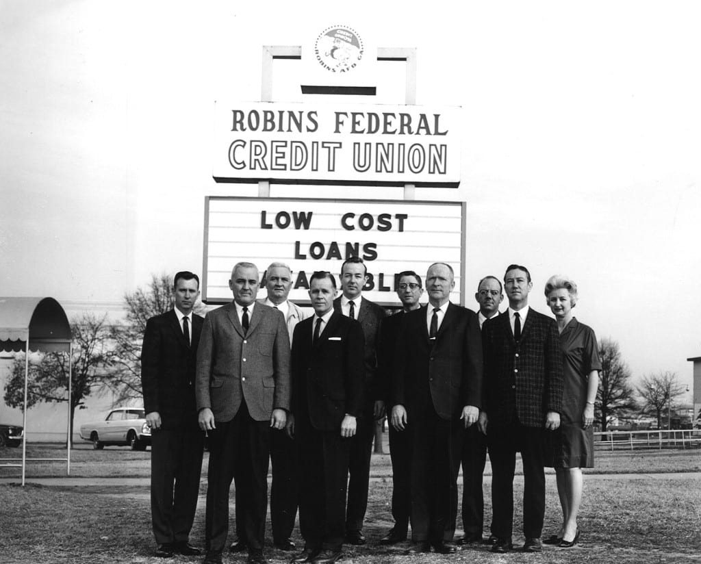 An old photograph of the original 13 members of Robins Financial Credit Union.