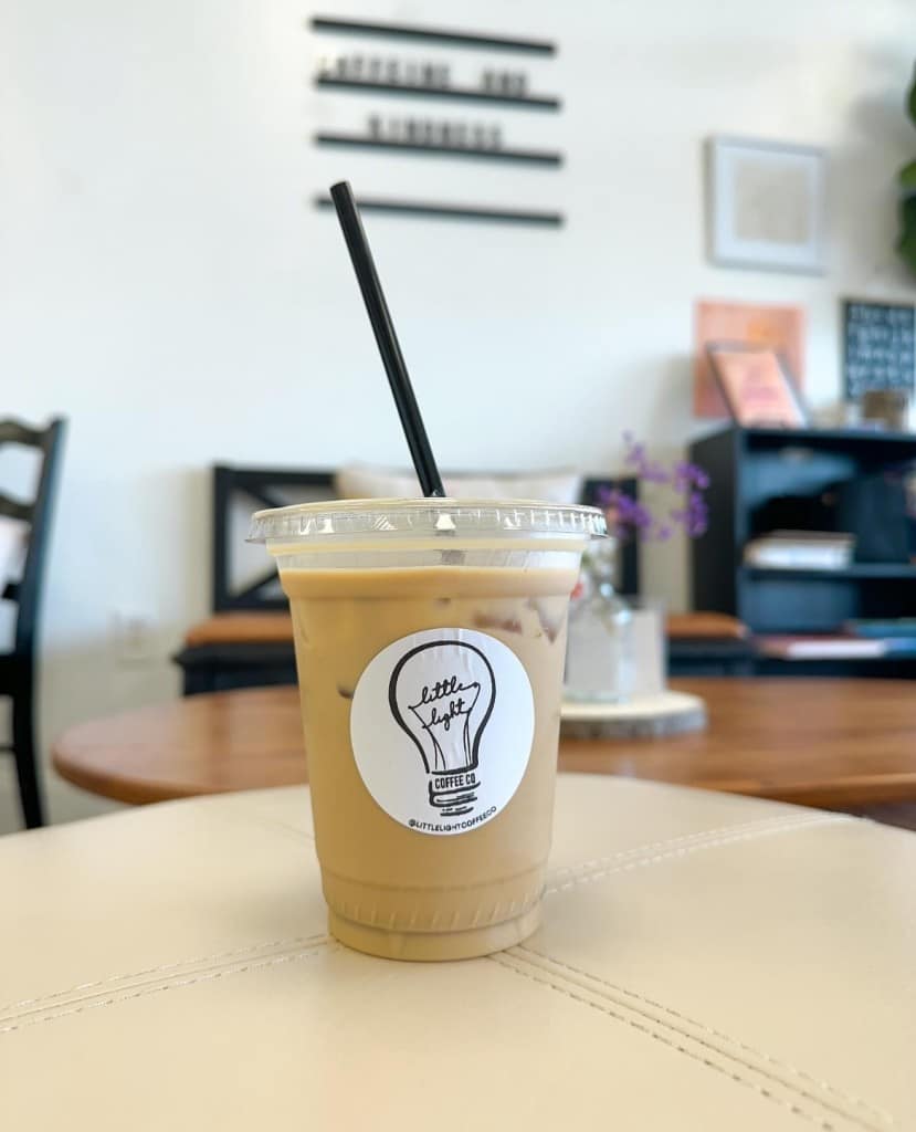 Photo of a small iced coffee with a lightbulb sticker placed on cup. 
