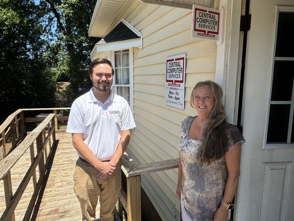 a man and woman standing outside of Central Computer Services in Perry