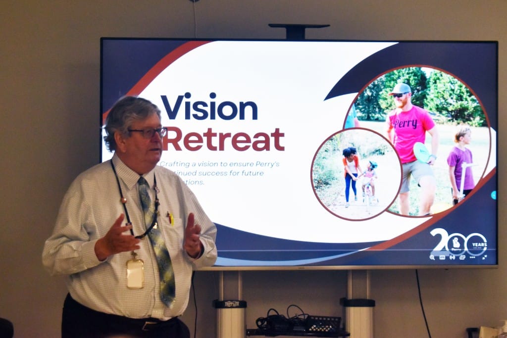 Man standing in front of a board giving a presentation.