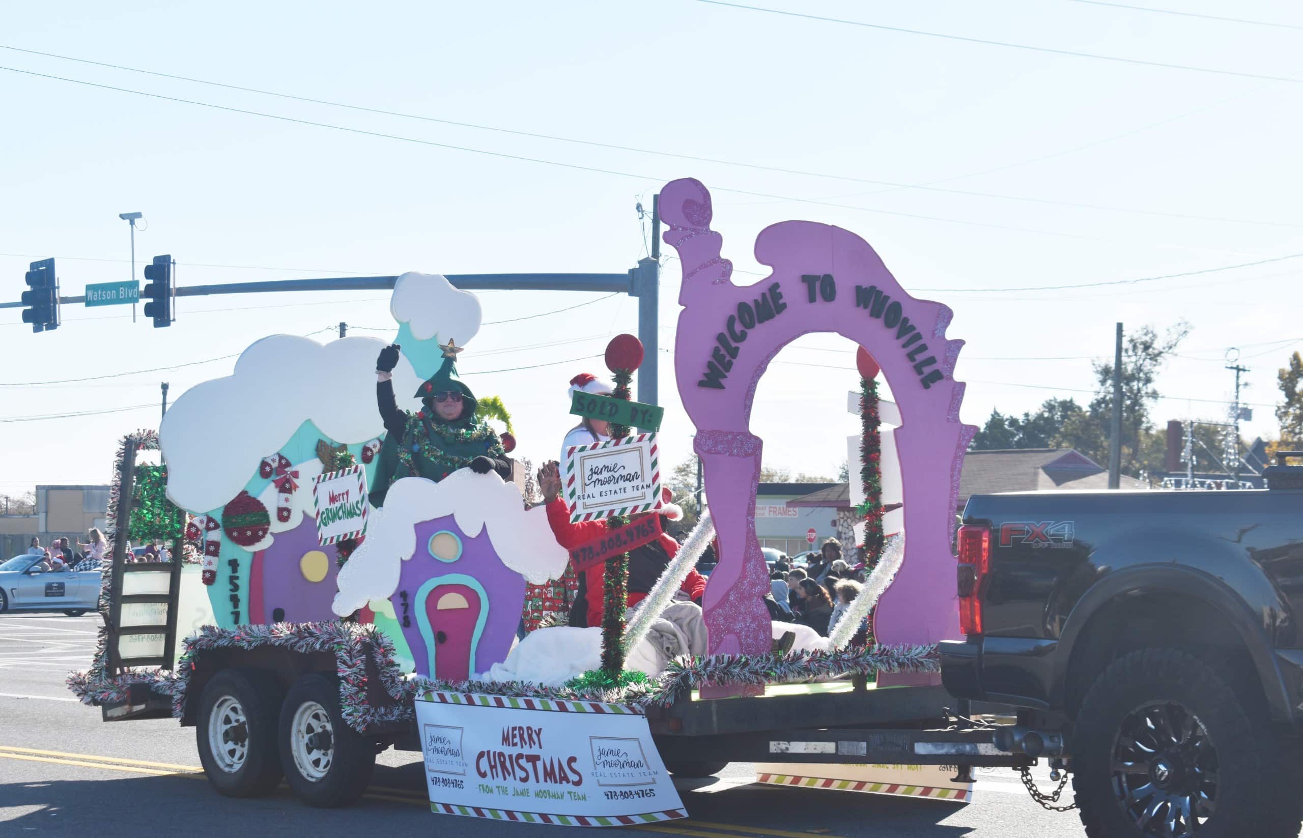 A float representing "Whoville." There is a woman on the float dressed as a Christmas tree.