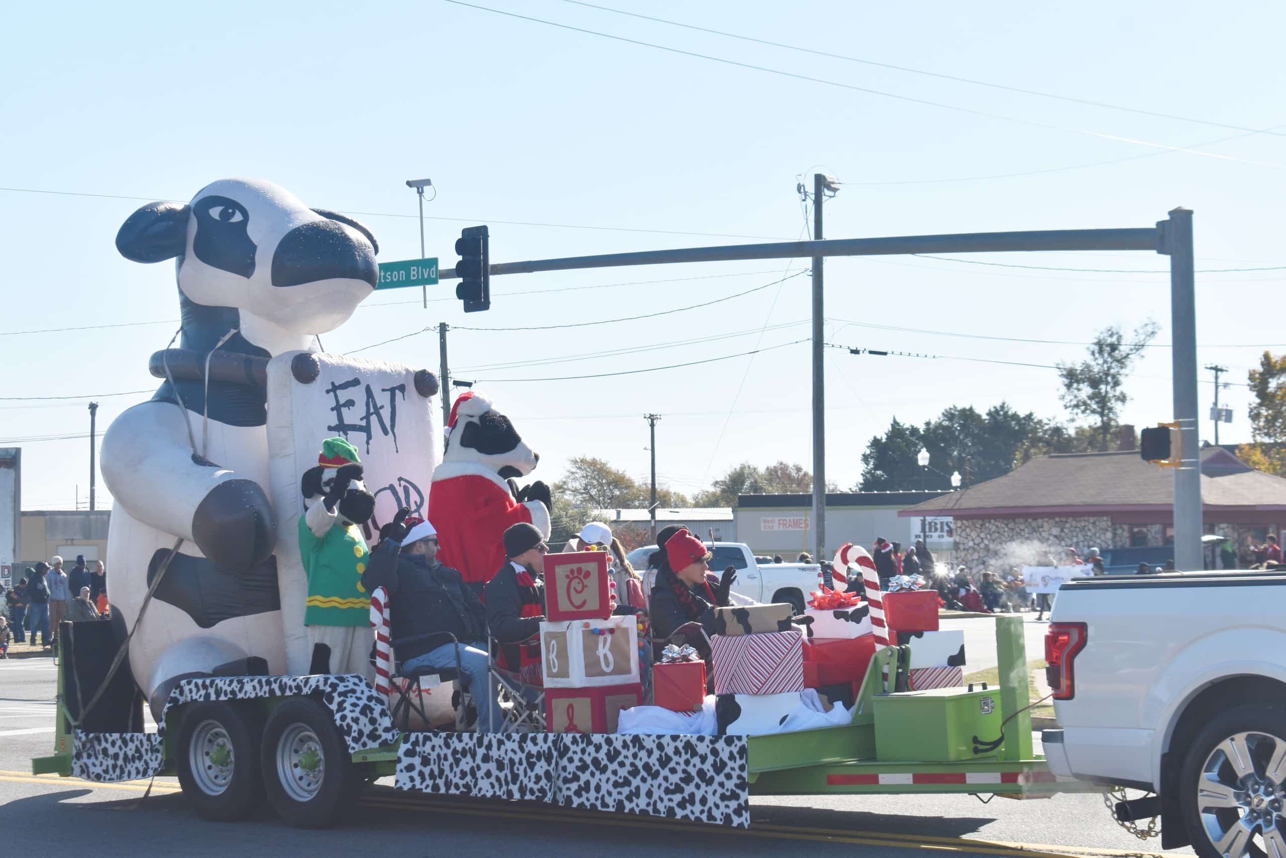 The Chick Fil A has their famous cow and children sitting on the float.