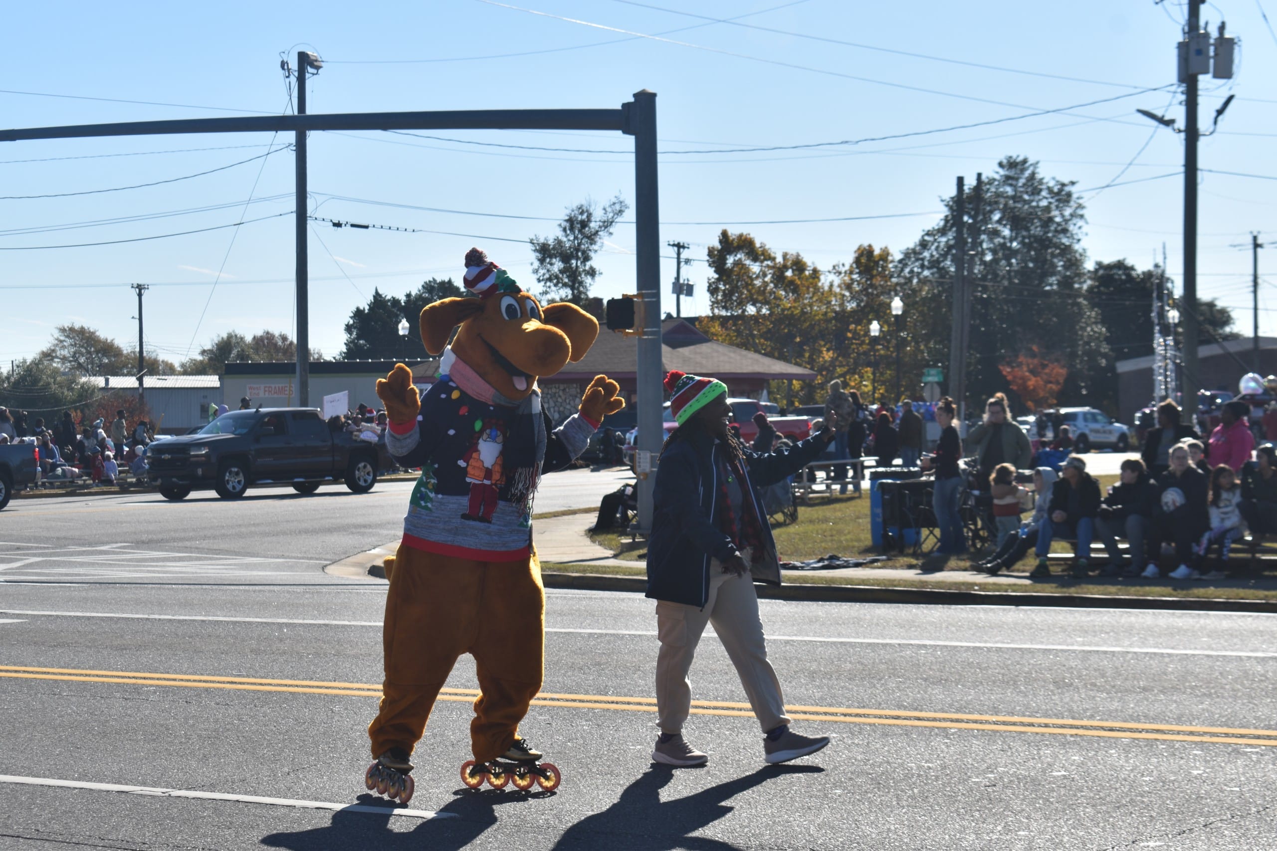 A person in a character costume skating through the parade.