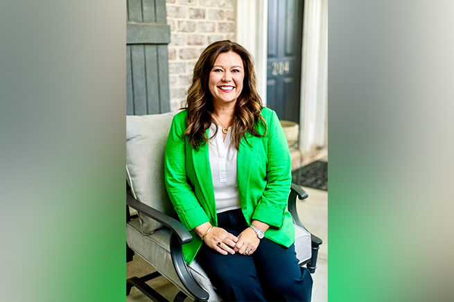 A woman sitting on a chair smiling.