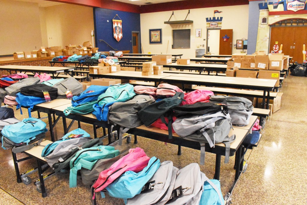 Different color backpacks on a table.
