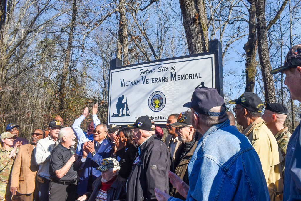 A group of people looking up at a sign.