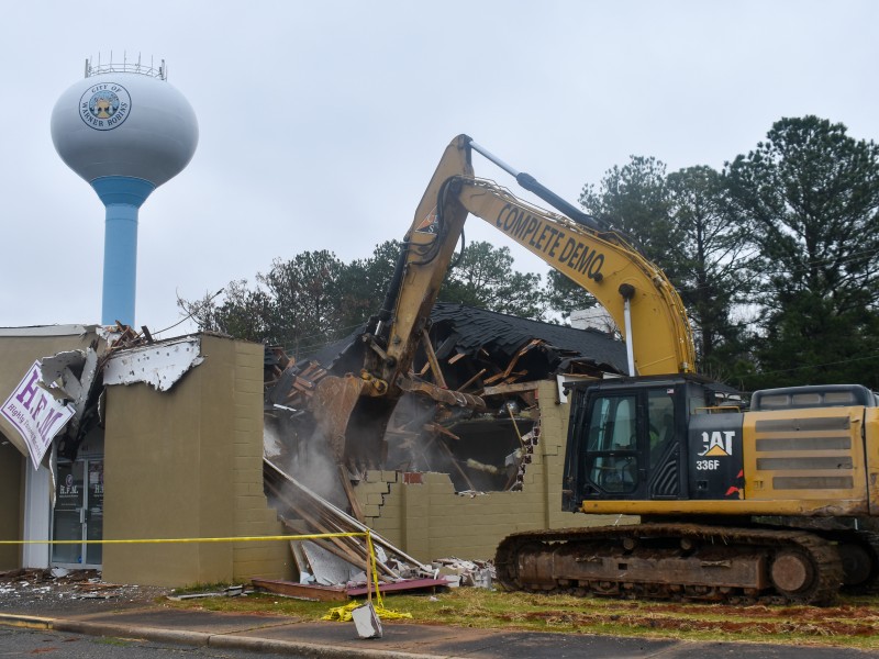 An excavator tearing down a building.