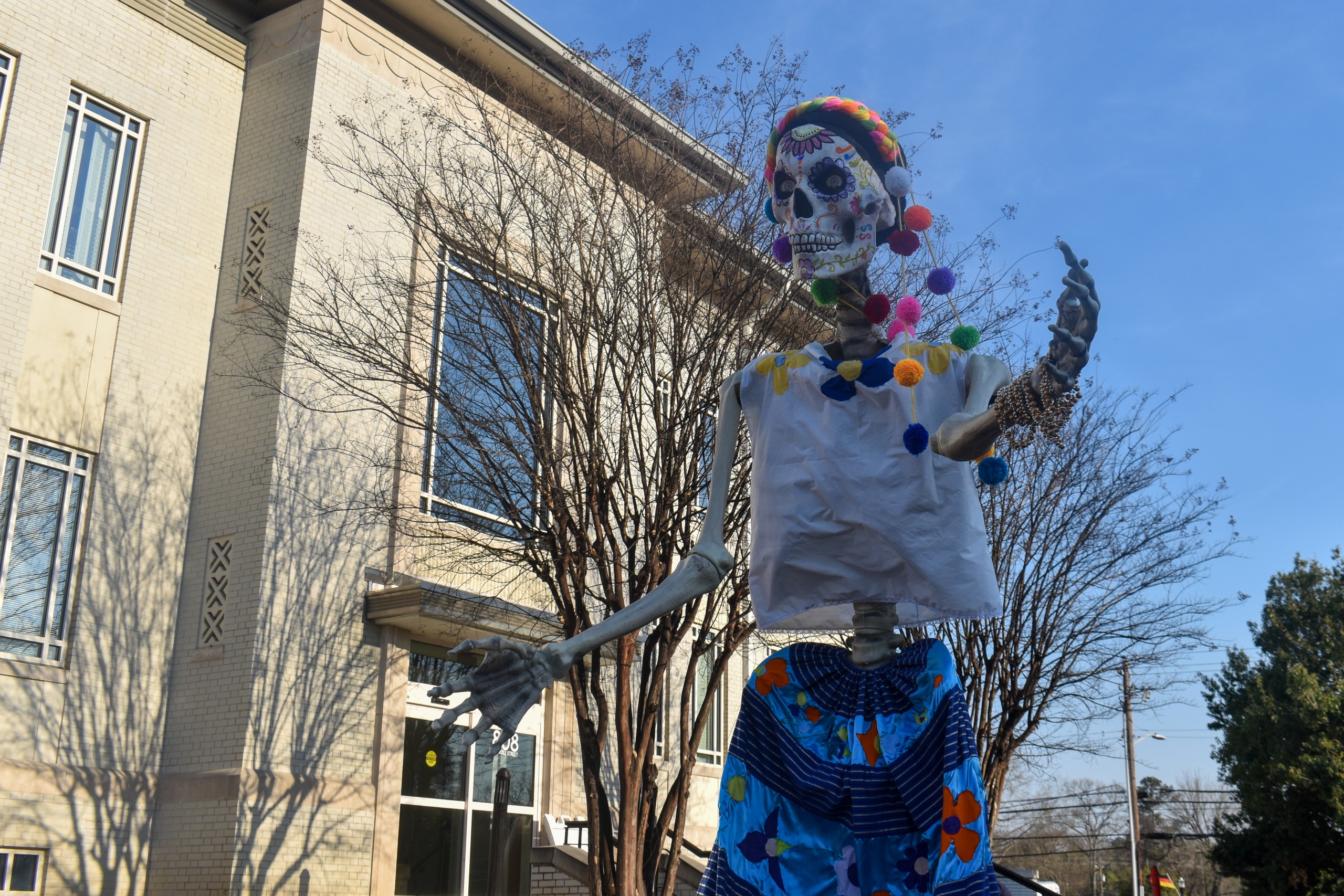 A big skeleton in a dress and headwear.