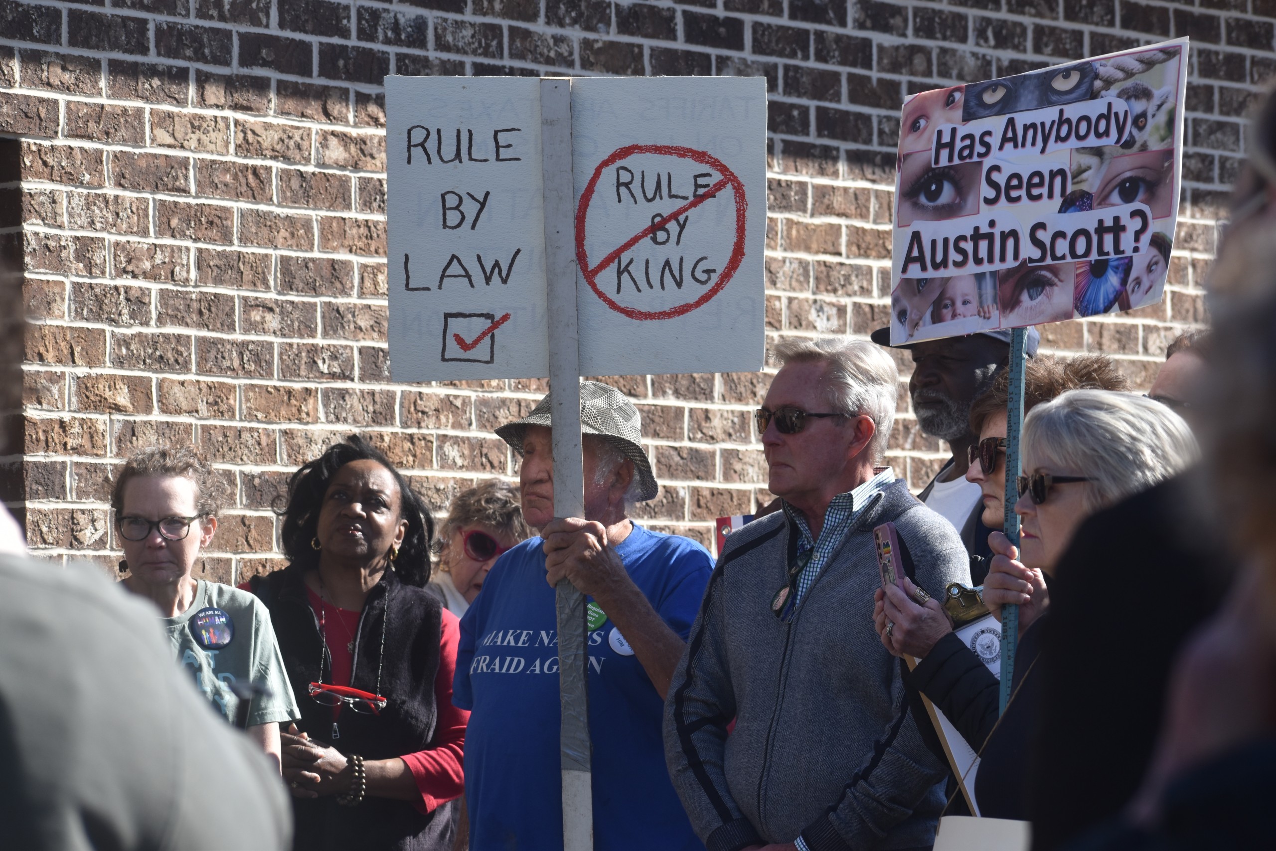 A man in a blue shirt holding up a sign.