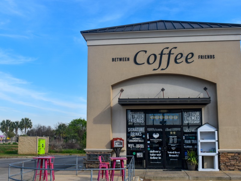 A building with "Between Friends Coffee" in black letters.