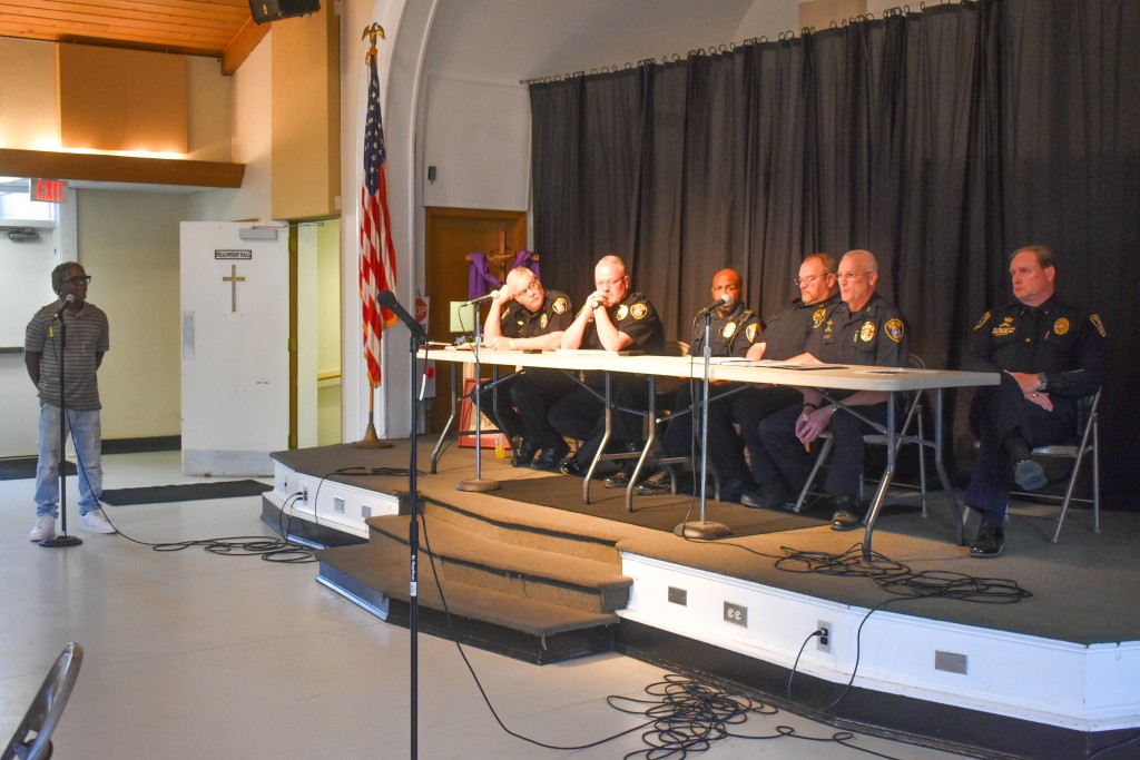 Men in police uniform sitting at a table.