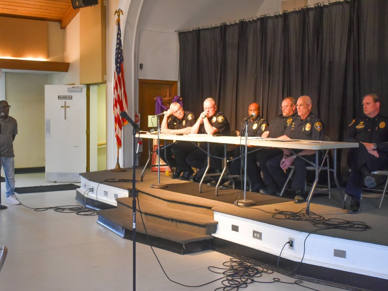 Men in police uniform sitting at a table.