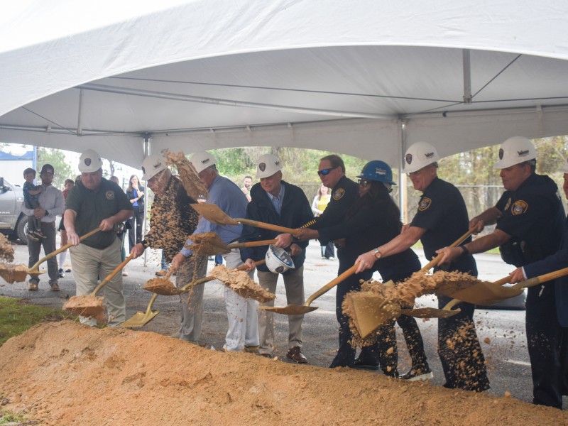 A group of people shoveling dirt.