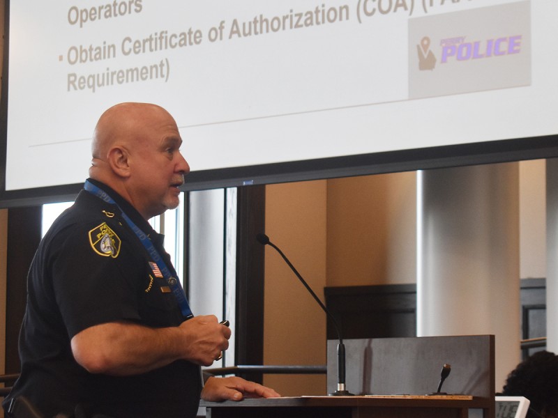 A man in a police uniform speaking at a podium.