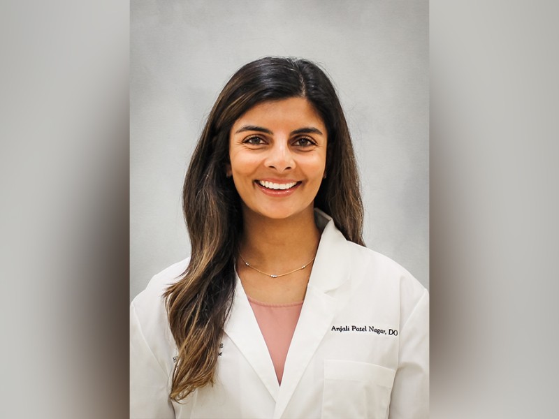 A woman with white coat smiling for the camera.