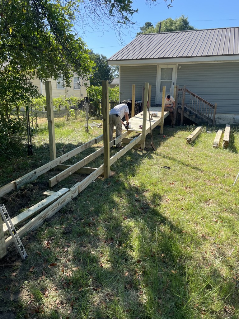 A man building a ramp on a sunny day.