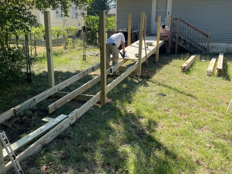 A man building a ramp on a sunny day.