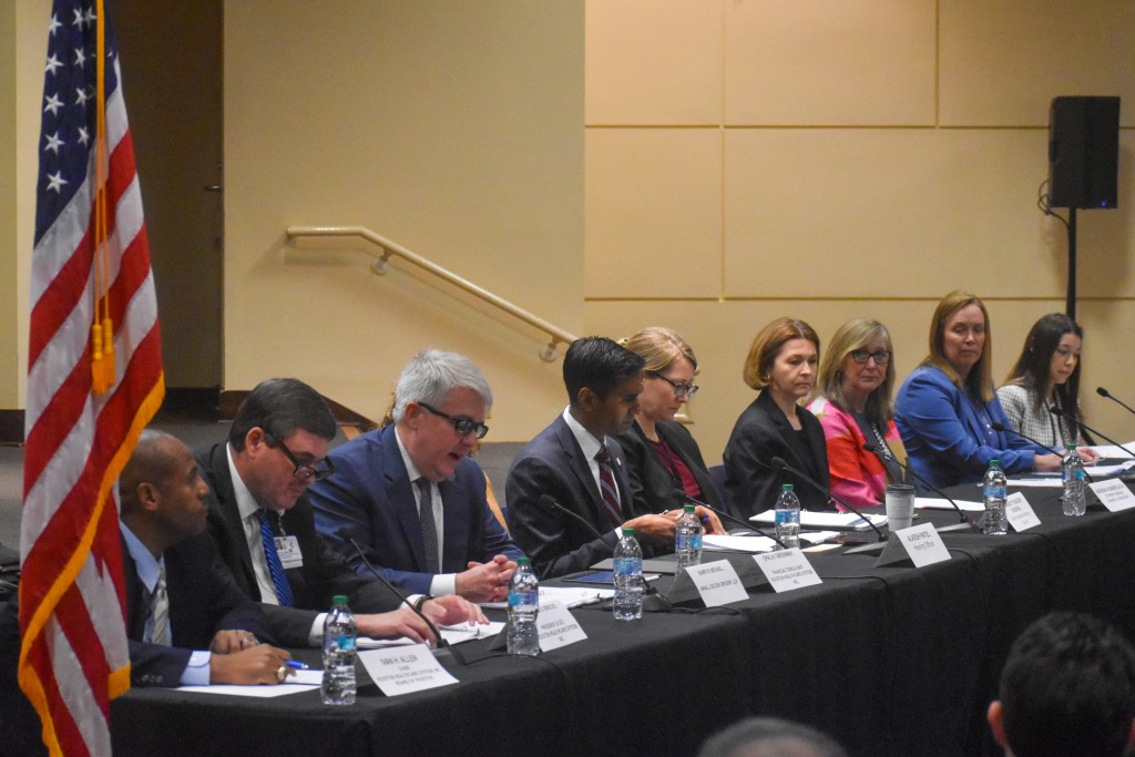 People sitting at a table facing the audience.