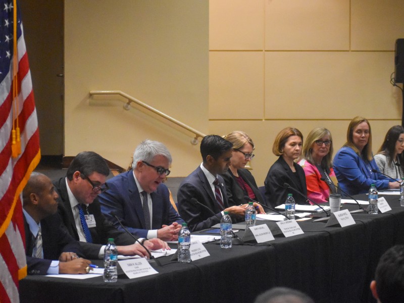People sitting at a table facing the audience.