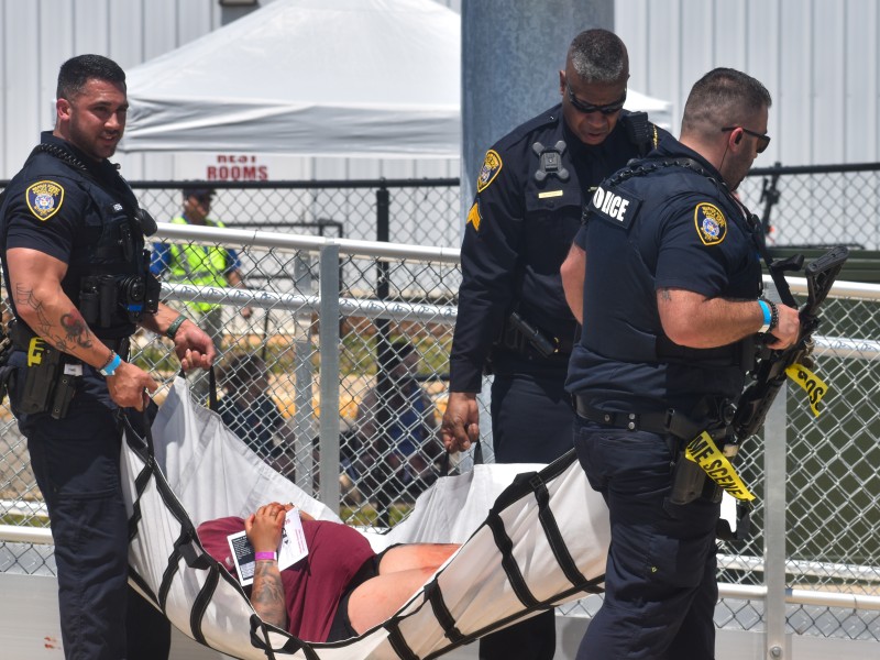 Men in police uniforms carrying a women.