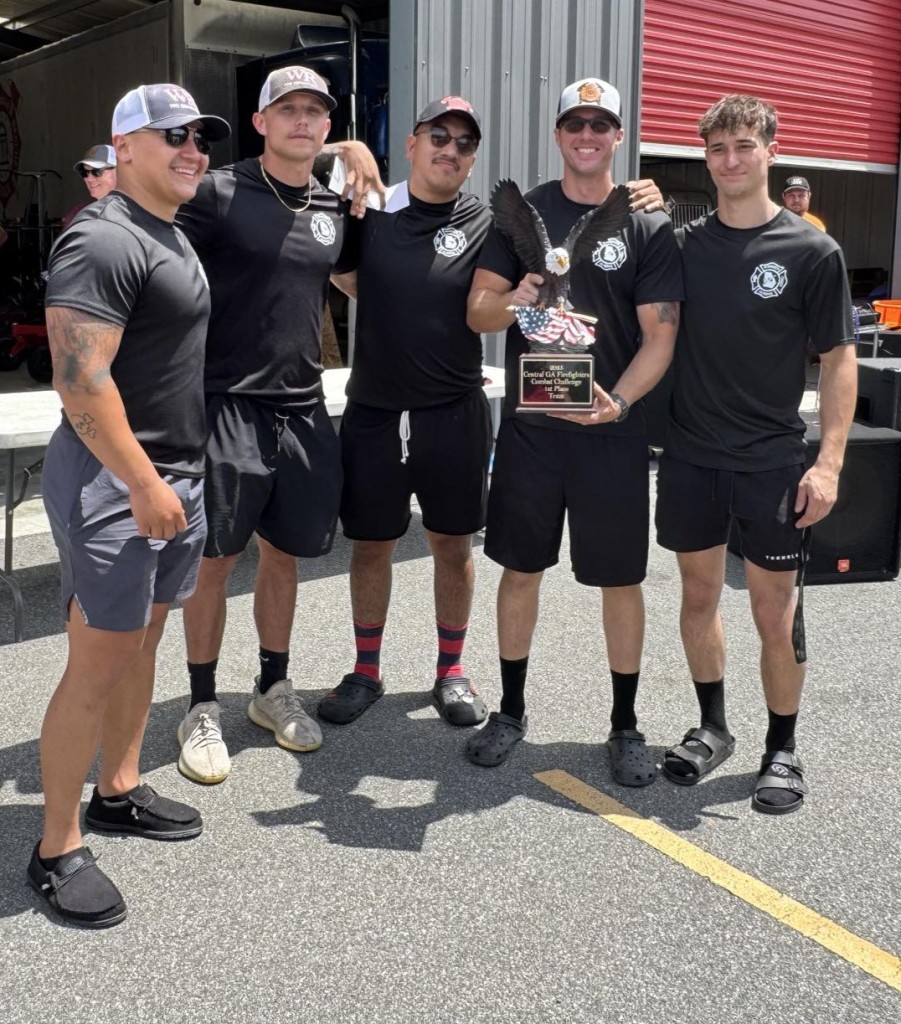 A group of men wearing black shirts pose for a photo.