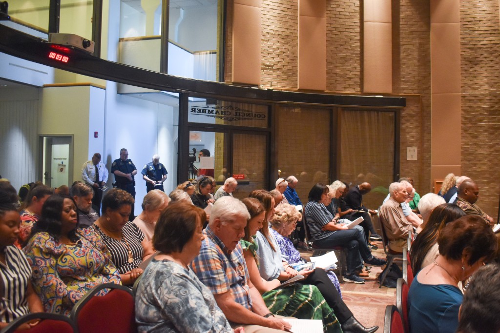 People sitting down with their heads down praying.