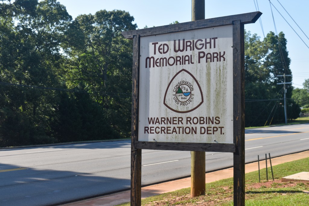 A sign with a white background. Black letters say "Ted Wright Memorial Park."