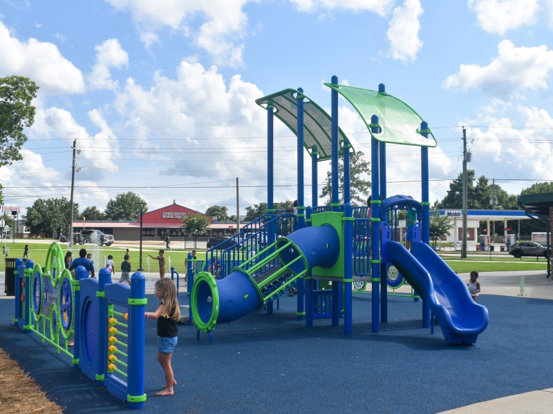 A blue and green playground. A slide is seen in the photo.