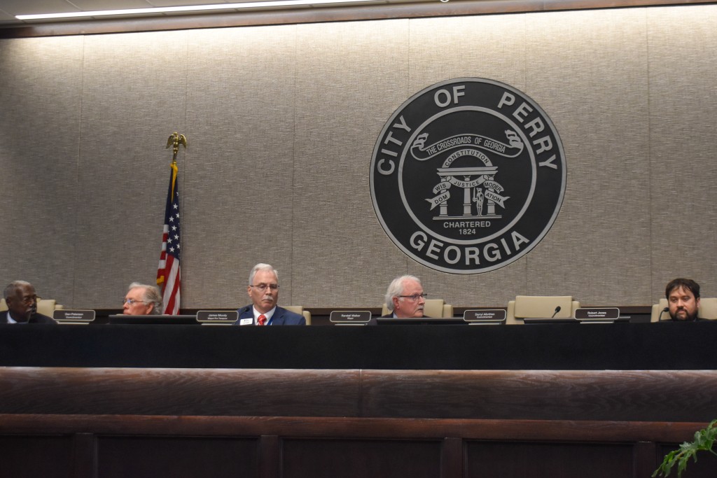 For men sitting in chairs behind a table.