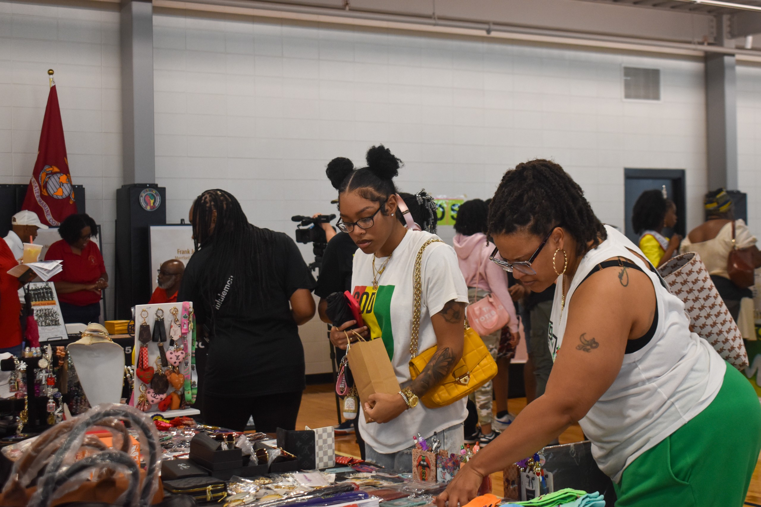 Two women looking at jewelry on the table.
