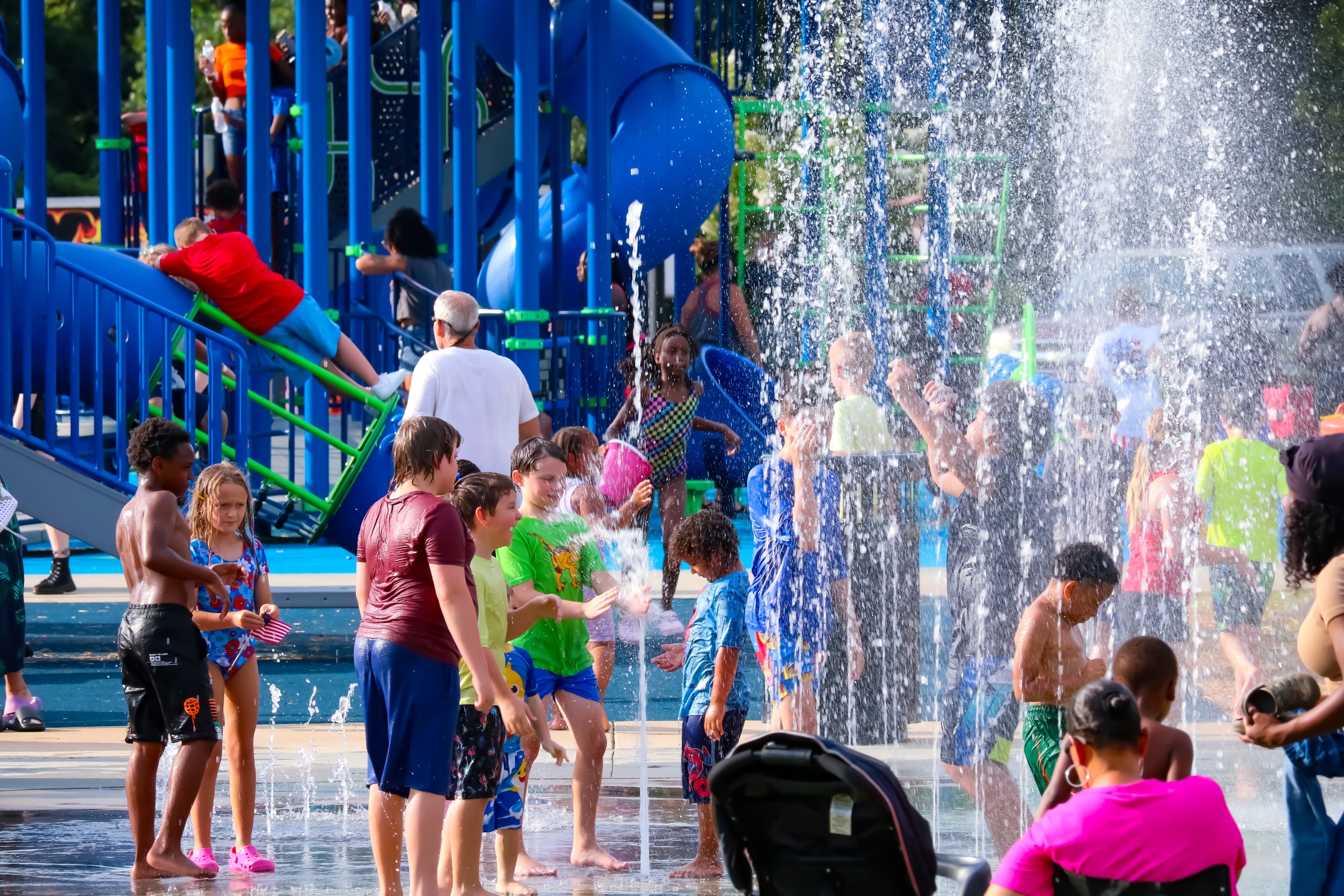 Children playing in the splash pad. Water is seen going up into the air.