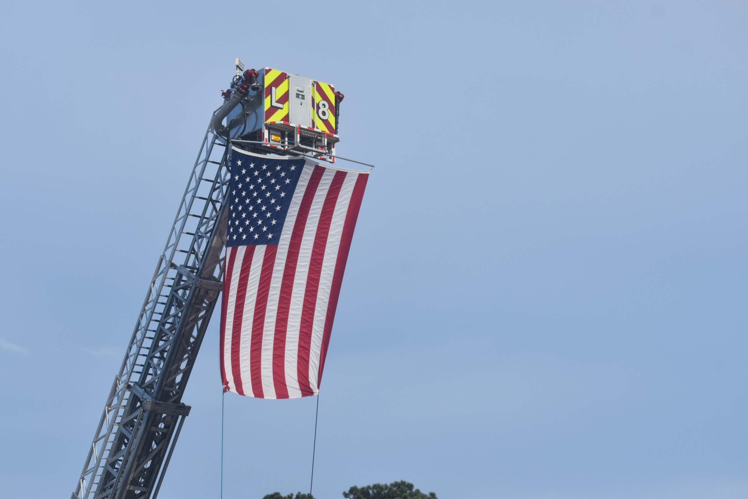 An American Flag hanging up by a Fire Truck.