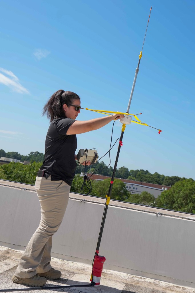 A woman holding and setting up an antenna.