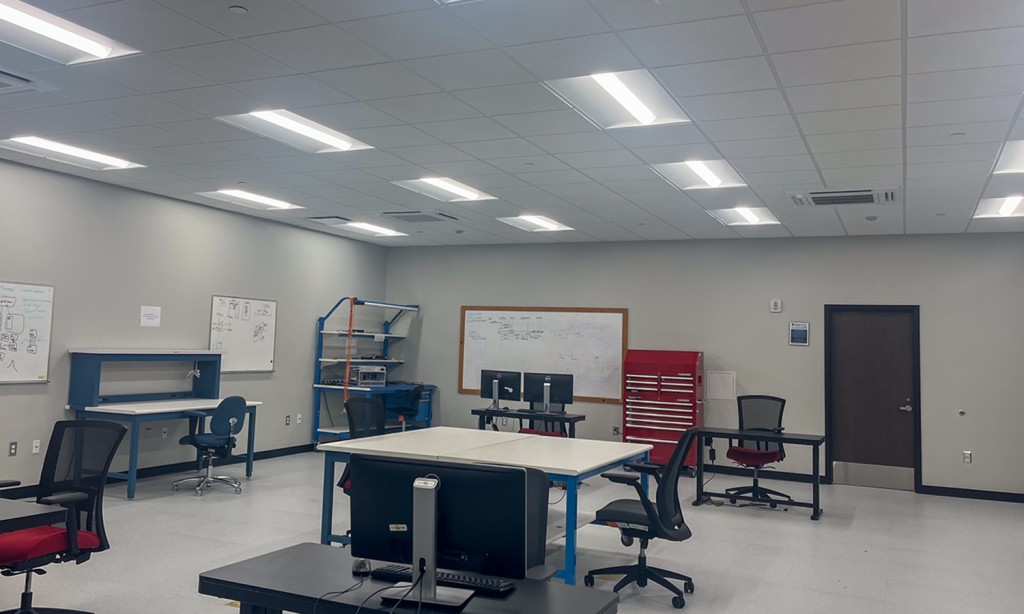 A room with desks and white boards.