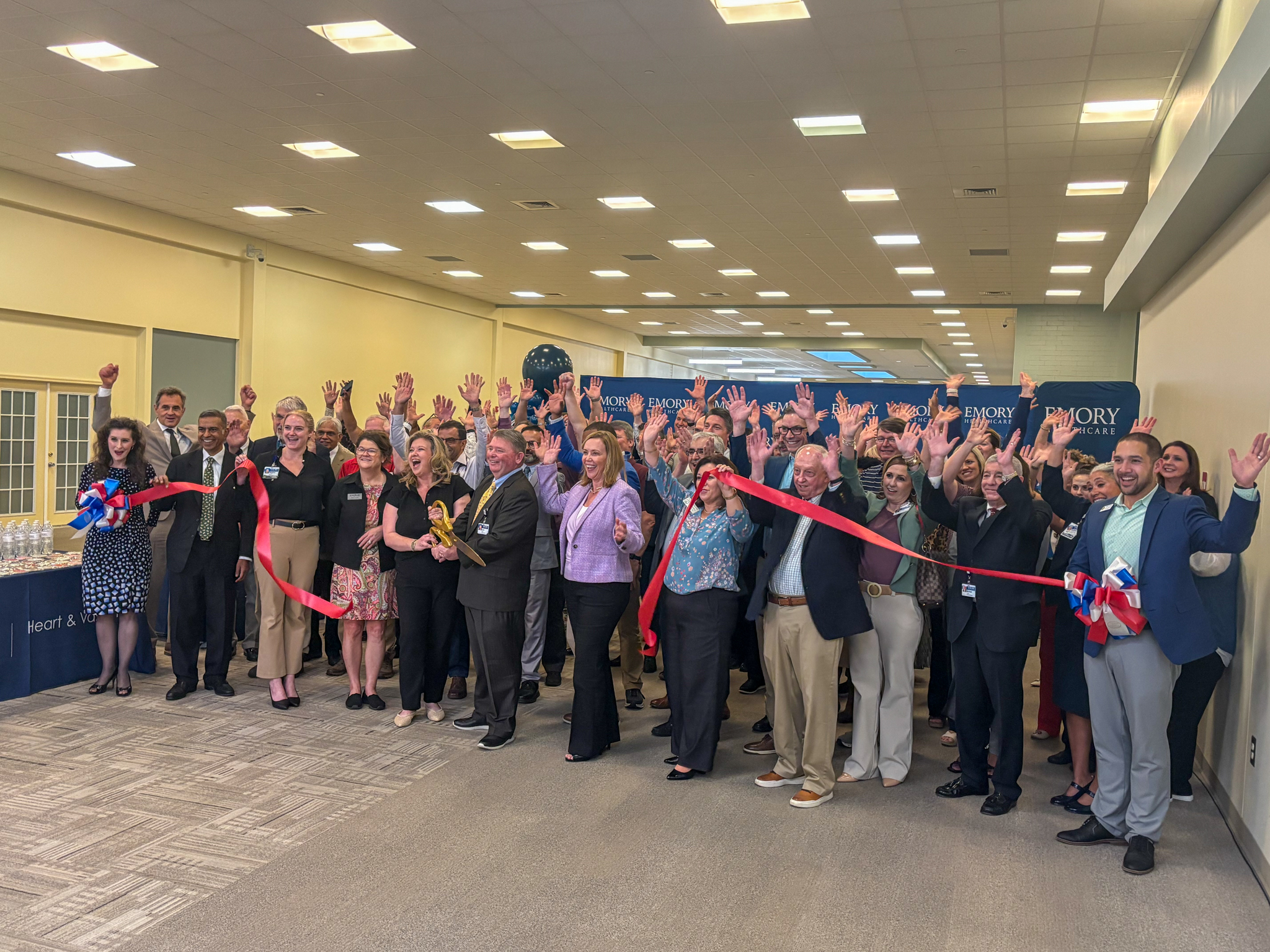 group of people celebrating a ribbon cutting