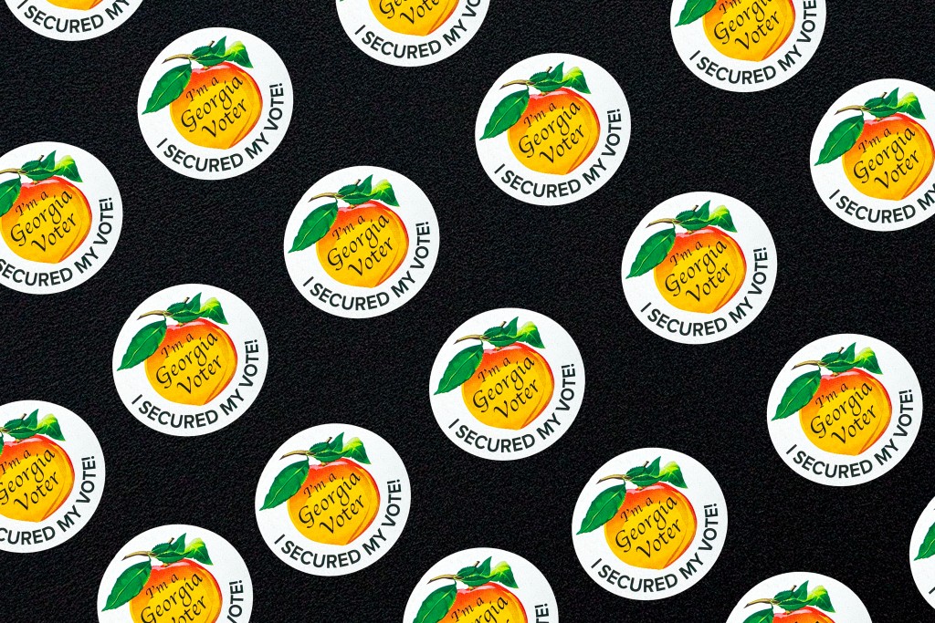 Multiple Georgia voter stickers on a black background. 
