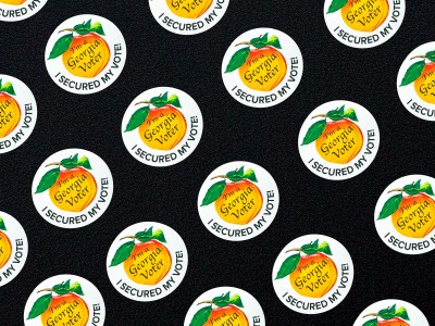 Multiple Georgia voter stickers on a black background.