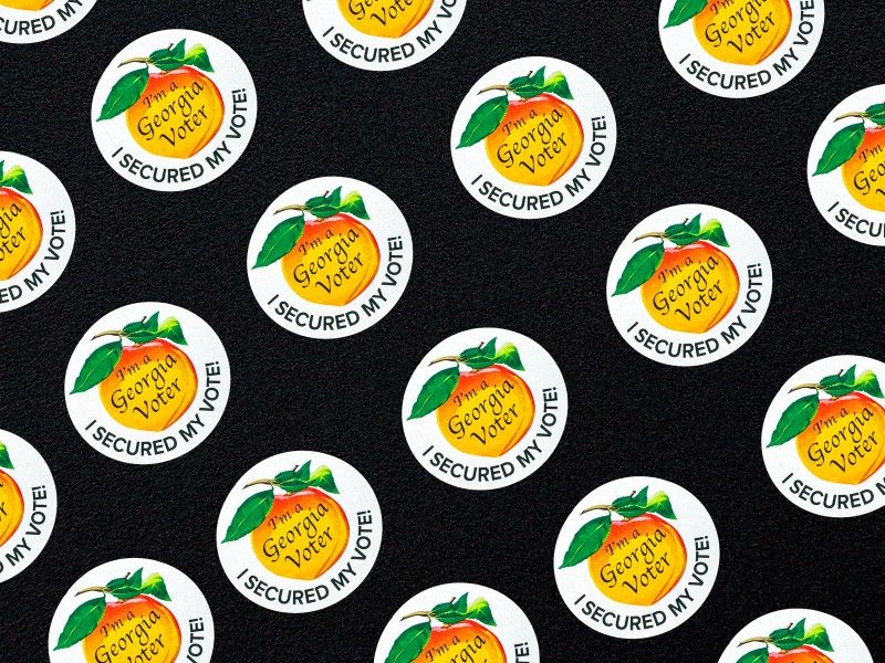 Multiple Georgia voter stickers on a black background.