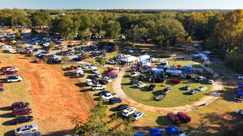 An overhead shot of Heritage Oaks Park. There are cars parked on the grass and tents set up. 